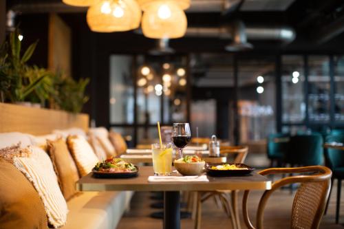 a table with two plates of food and a glass of wine at Coloft in Lesquin
