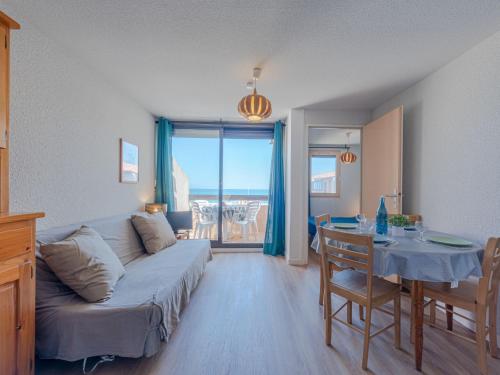 a living room with a couch and a table at Apartment Front de Mer-8 by Interhome in Le Barcarès