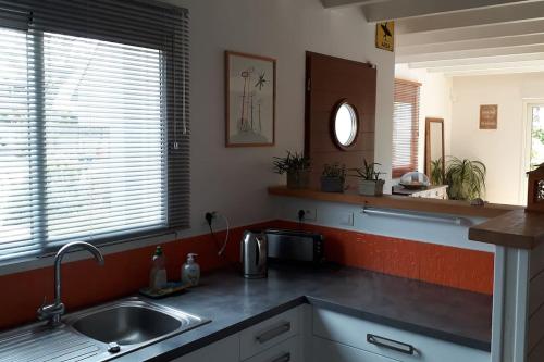 a kitchen with a sink and a counter top at Maison en bois avec piscine à 1000 m des plages. in Guidel