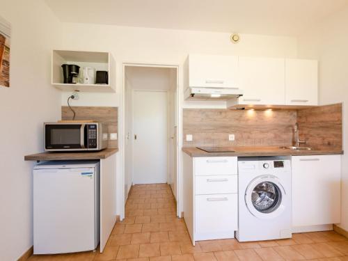 a kitchen with a washing machine and a microwave at Apartment Les Jardins de la Nartelle Beach by Interhome in Sainte-Maxime