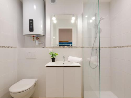 une salle de bain blanche avec des toilettes et un lavabo dans l'établissement Apartment Le Domaine de la Croisette by Interhome, à Sainte-Maxime