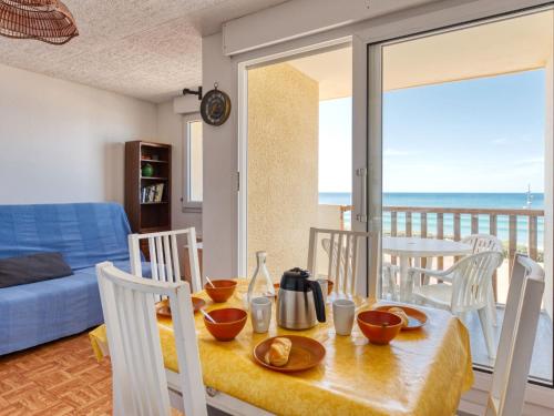 a dining room with a table and chairs with a view of the ocean at Apartment Ortal Océan-2 by Interhome in Lacanau-Océan