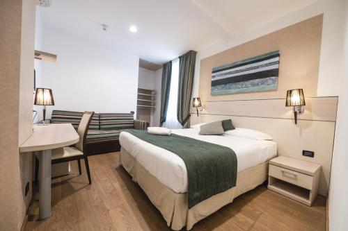 a hotel room with a bed and a desk at Coccodrillo Hotel & Apartments in Varazze