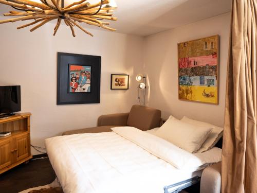 サンモリッツにあるチェサ Ludainsのベッドルーム(白いベッド1台、テレビ付)