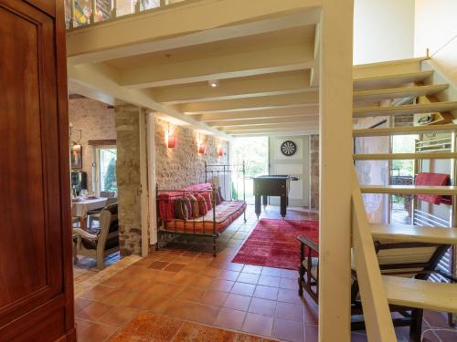 a living room with a staircase and a grand piano at Holiday Home Moulin De Mois by Interhome in Joussé