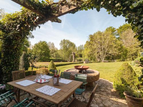 a patio with a table and chairs in a garden at Holiday Home Moulin De Mois by Interhome in Joussé