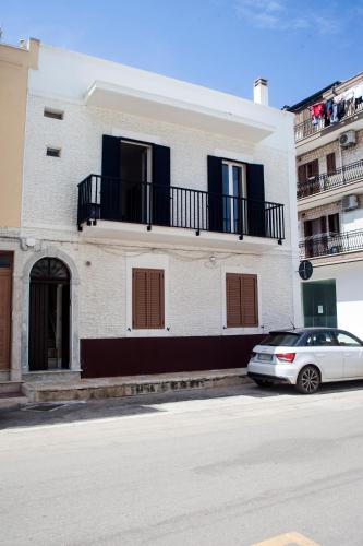 a white building with a car parked in front of it at Al Porticciolo di Savelletri in Savelletri di Fasano