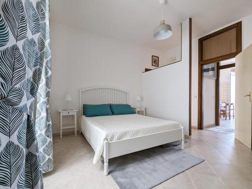 Dormitorio blanco con cama con almohadas azules en Al Porticciolo di Savelletri, en Savelletri di Fasano