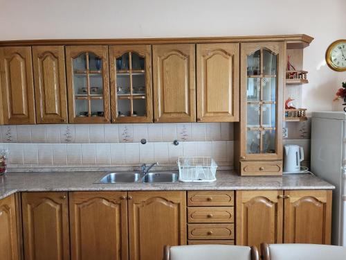 a kitchen with wooden cabinets and a sink at Apartman Martina in Gospić