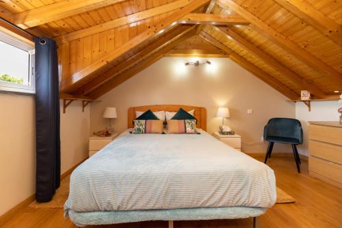 a bedroom with a large bed in a room with wooden ceilings at Stay in Todi - Alojamento Local in Setúbal