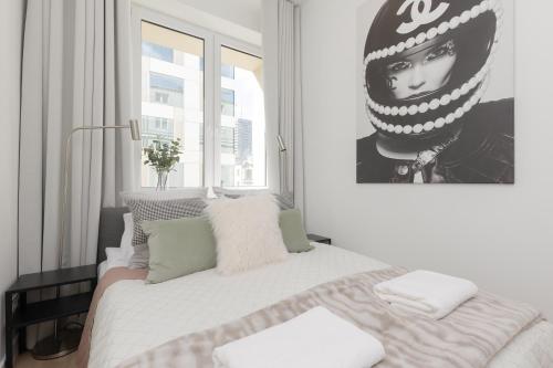 Fashionable City Center Apartment by Renters في وارسو: غرفة نوم بسرير كبير مع صورة على الحائط