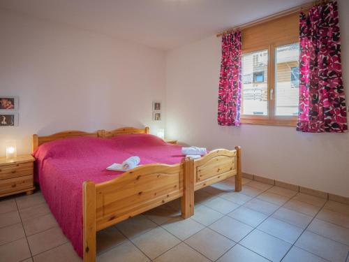 een slaapkamer met een houten bed en een raam bij Apartment La Rèze No 6 by Interhome in Ovronnaz