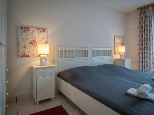 een slaapkamer met een bed en twee nachtkastjes met lampen bij Apartment La Réze No 5 by Interhome in Ovronnaz