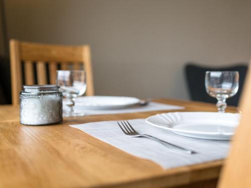 a wooden table with a plate and glasses on it at Apartment B907 by Interhome in Lahnstein