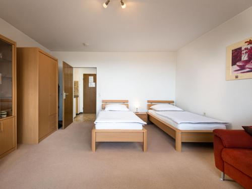 ラーンシュタインにあるApartment B715 by Interhomeのベッド2台とソファが備わる客室です。