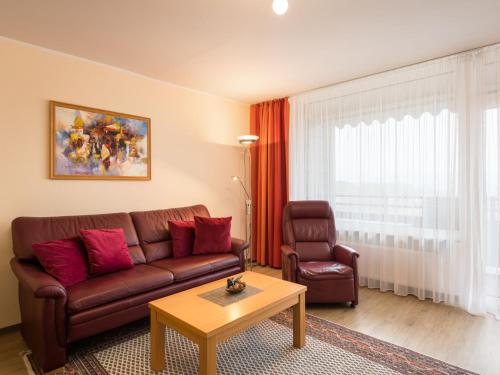 ein Wohnzimmer mit einem braunen Sofa und einem Tisch in der Unterkunft Apartment A808 by Interhome in Lahnstein
