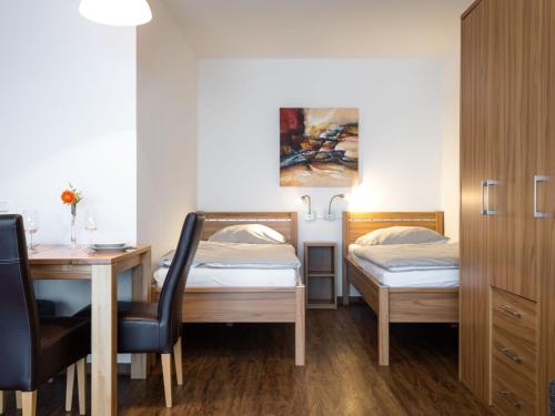 a small room with two beds and a desk and a table at Apartment A707 by Interhome in Lahnstein