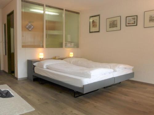 1 cama grande en una habitación con 2 lámparas. en Studio Silence-4 by Interhome, en Zermatt