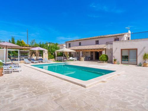 a villa with a swimming pool and a house at Holiday Home Es Cos by Interhome in Moscari