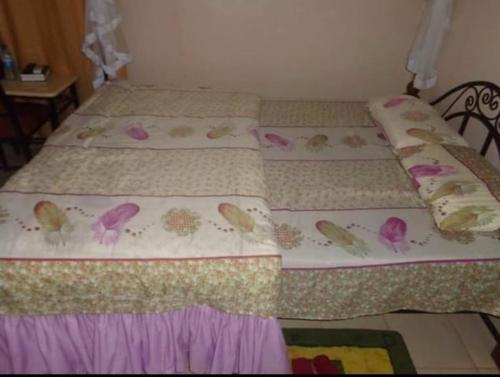 a bedroom with two beds with butterflies on them at Grenville Hotel in Oyugis