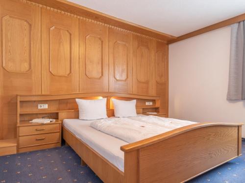 1 dormitorio con 1 cama grande y armarios de madera en Apartment Apart Romantica - KPL214 by Interhome, en Kappl