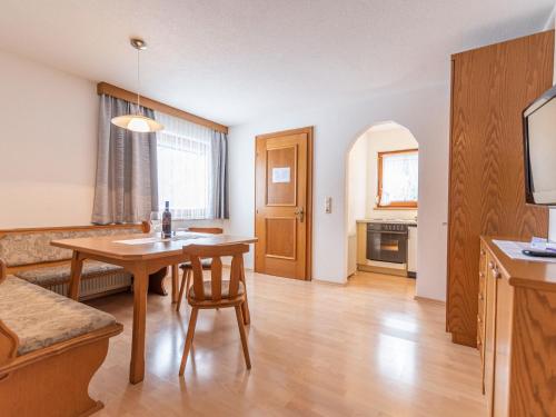 kuchnia i salon ze stołem i krzesłami w obiekcie Apartment Apart Romantica-3 by Interhome w mieście Kappl