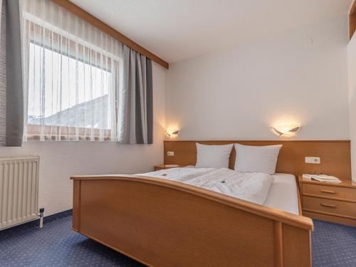 sypialnia z dużym łóżkiem i oknem w obiekcie Apartment Apart Romantica-3 by Interhome w mieście Kappl