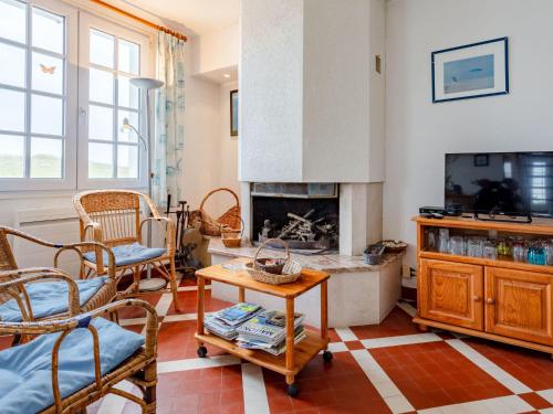 - un salon avec une cheminée, une table et des chaises dans l'établissement Holiday Home Les Dunes by Interhome, à Saint-Germain-sur-Ay