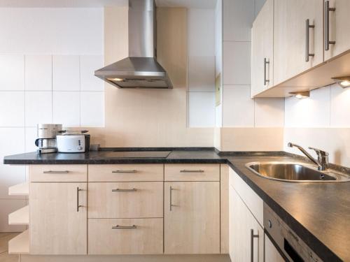 - une cuisine avec des placards blancs et un évier dans l'établissement Apartment B1013 by Interhome, à Lahnstein