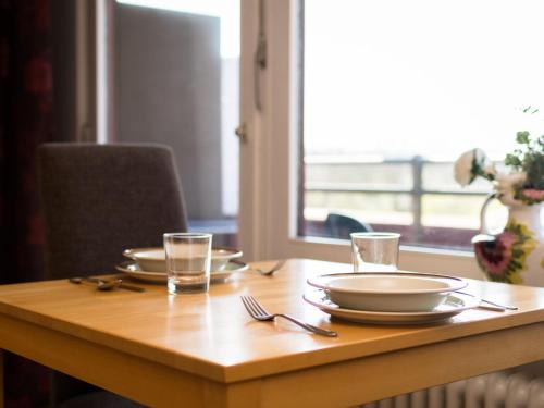 einem Holztisch mit Tellern und Gläsern darauf in der Unterkunft Apartment B512 by Interhome in Lahnstein