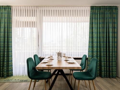 a table with green chairs in front of a window at Apartment A109 by Interhome in Lahnstein