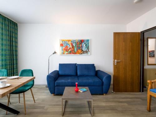 a living room with a blue couch and a table at Apartment A109 by Interhome in Lahnstein