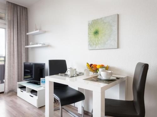 a white dining room table with chairs and a television at Apartment A1005 by Interhome in Lahnstein
