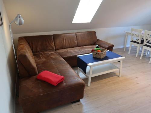 a living room with a brown couch and a table at Apartment Müritz Ferienpark Röbel-8 by Interhome in Röbel