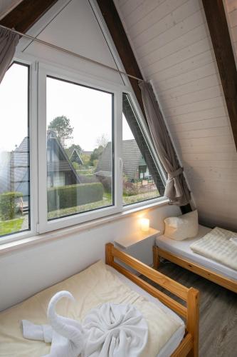 a bedroom with two beds and two windows at Holiday Home Fedderwardersiel-6 by Interhome in Fedderwarderdeich
