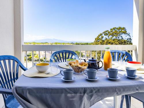 une table avec un chiffon de table bleu, des tasses et des boissons dans l'établissement Apartment Les Frégates-15 by Interhome, à Saint-Cyprien