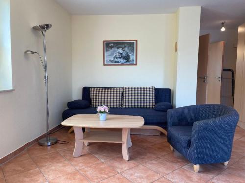 een woonkamer met een bank, een tafel en een stoel bij Apartment Müritz Ferienpark Röbel-14 by Interhome in Röbel