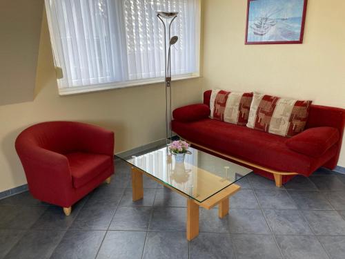 - un salon avec deux canapés rouges et une table en verre dans l'établissement Apartment Müritz Ferienpark Röbel-16 by Interhome, à Röbel