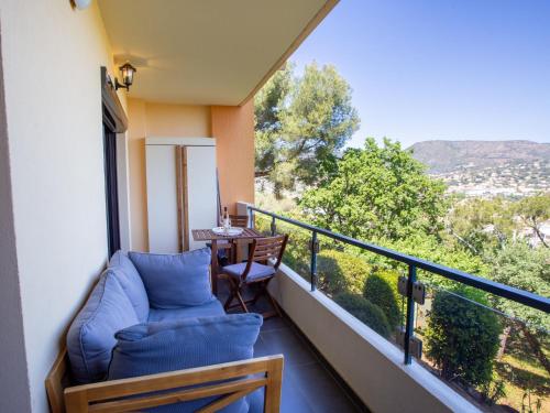 a balcony with a table and chairs and a view at Apartment Un autre jour ensoleillé by Interhome in Bormes-les-Mimosas
