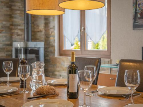 a bottle of wine sitting on a table with glasses at Chalet Ambigu by Interhome in Ovronnaz