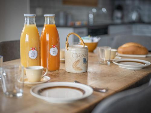 a table with two bottles of orange juice and bread at Chalet Phipalo by Interhome in Ovronnaz