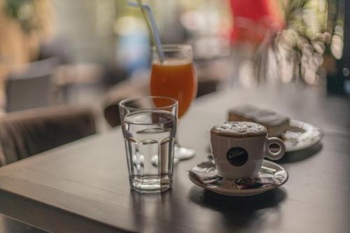 - une tasse de café et un verre de jus d'orange sur une table dans l'établissement Apartments Popadić with parking, à Herceg-Novi