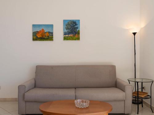 a living room with a couch and two paintings on the wall at Apartment Salvia by Interhome in Chiappa