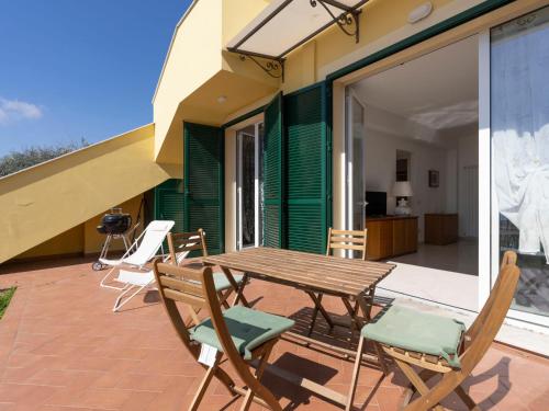 a wooden table and chairs on a patio at Apartment Salvia by Interhome in Chiappa