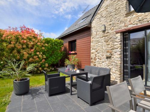 a patio with a table and chairs in front of a building at Holiday Home Le Graffi'Ty by Interhome in Besné