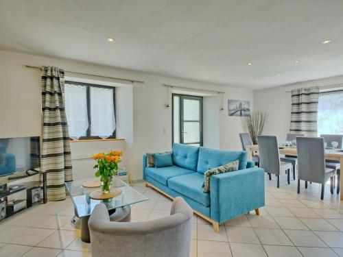 un salon avec un canapé bleu et une salle à manger dans l'établissement Holiday Home Le Graffi'Ty by Interhome, à Besné