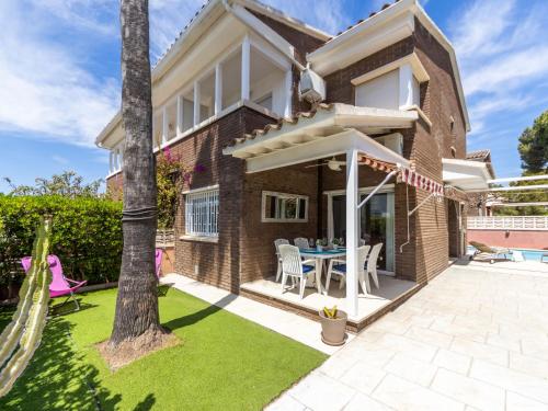 a house with a patio and a table and chairs at Holiday Home Canyadell by Interhome in Torredembarra