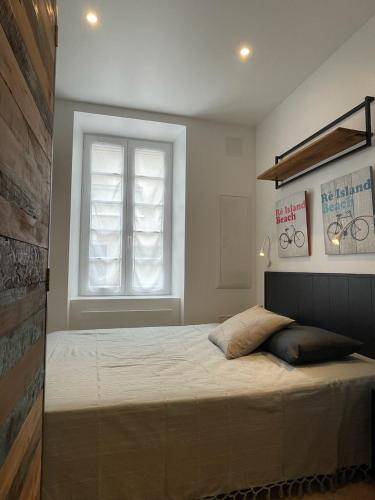 une chambre avec un grand lit avec une fenêtre dans l'établissement Le St Louis 1 Chambre aménagée avec cuisine, à La Rochelle