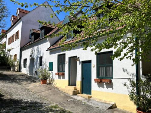 um edifício branco com uma porta azul numa rua em Apartment Hofgasse by Interhome em Mörbisch am See