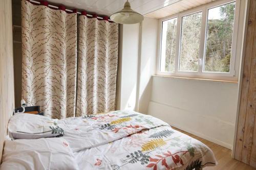 a bedroom with a bed and a window at L'Ancienne Colonie - maison conviviale au bord de la Gazeille - 8 pers in Le Monastier sur Gazeille